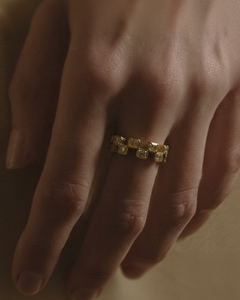 Close-up of Ukiyo n 1 gold eternity ring with yellow diamonds shown on model's hand in golden light