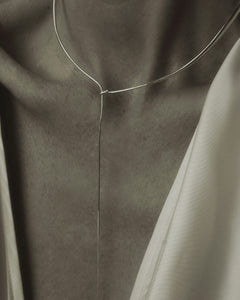 Color editorial of model's décolletage wearing Lera Treyger x Anouk Yve silver collar against beige silk top