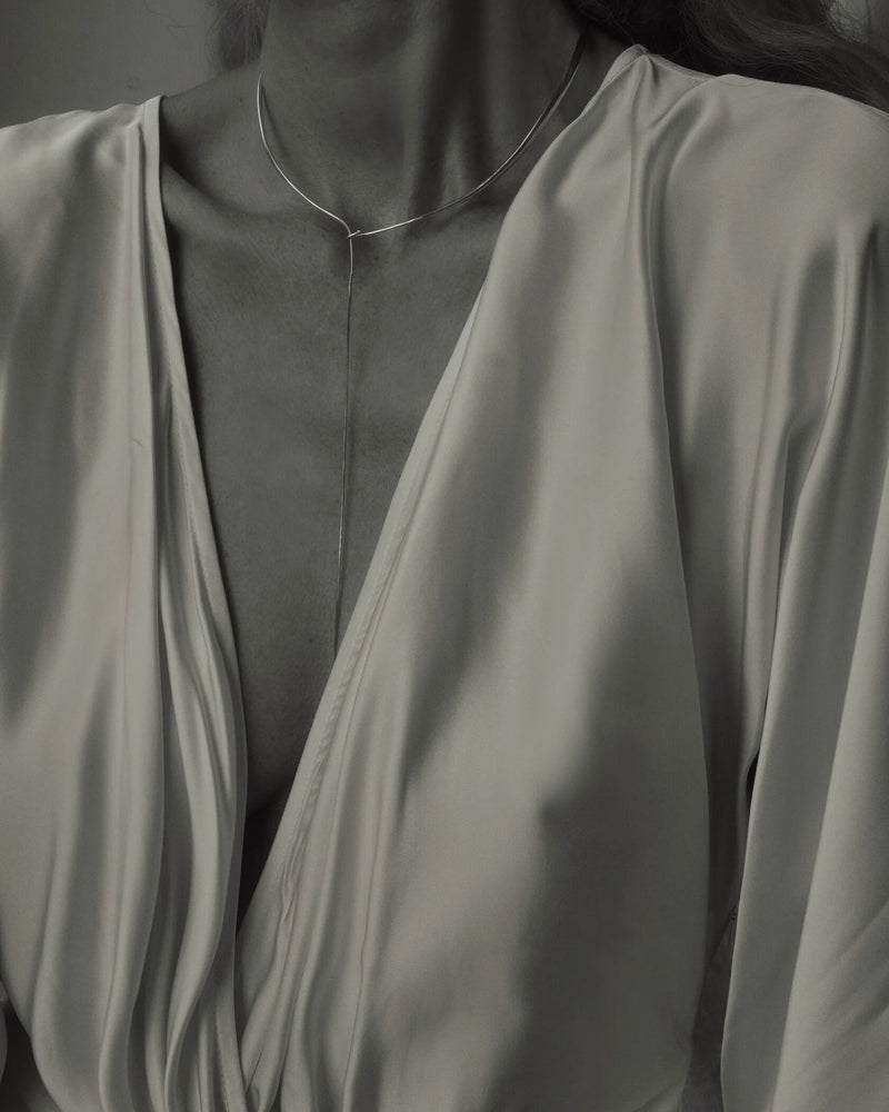 B&W of model in champagne silk wrap dress wearing Lera Treyger x Anouk Yve silver collar necklace