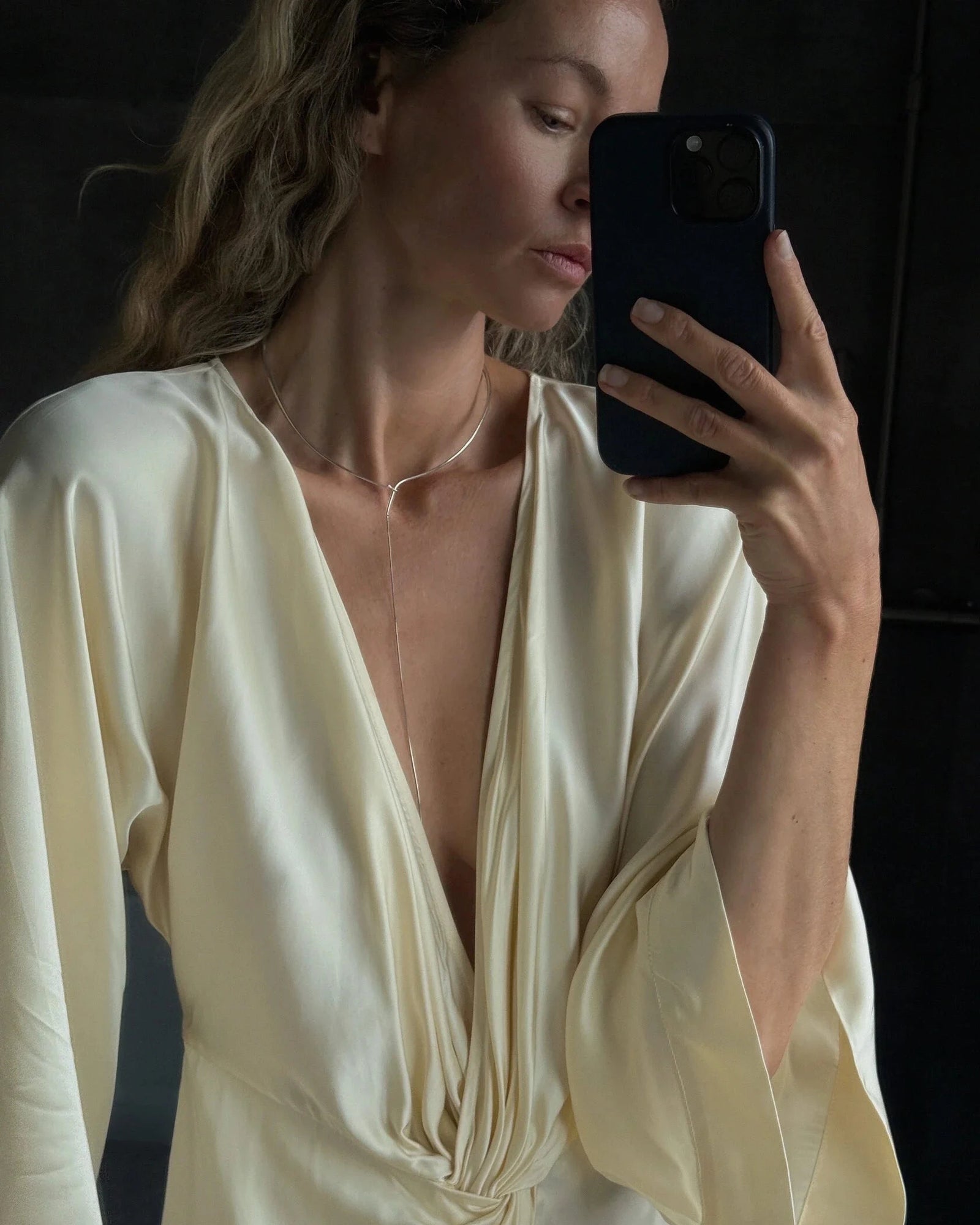 Mirror selfie of blonde model in cream silk dress wearing Lera Treyger x Anouk Yve silver collar with drop chain