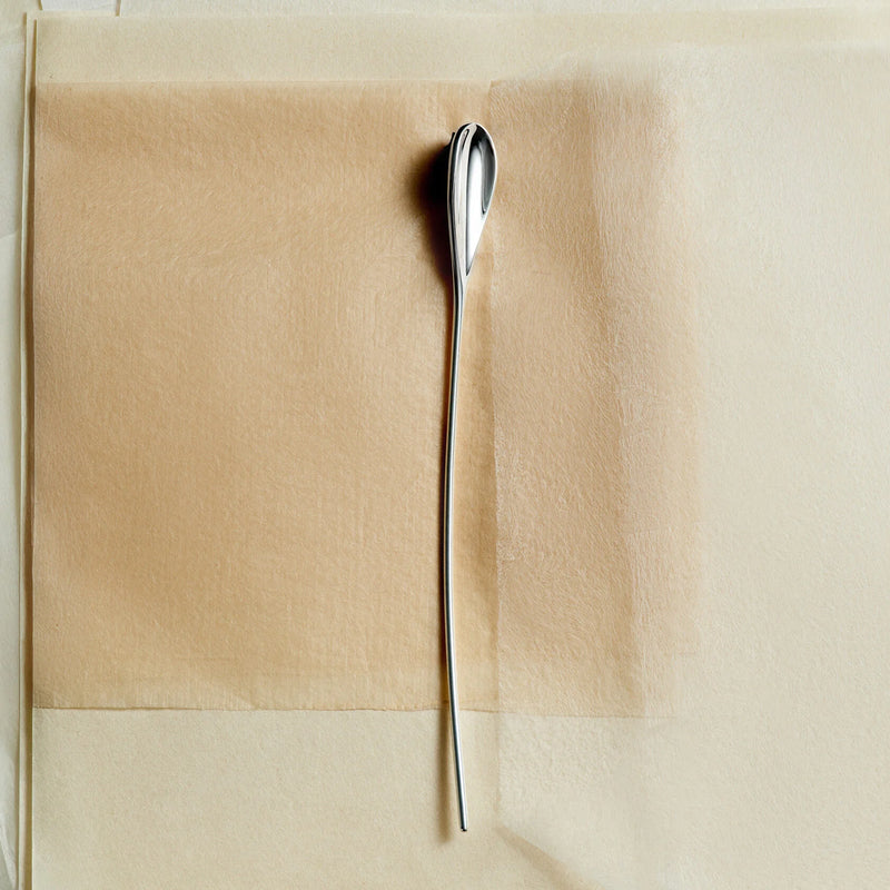 Top-down still life of Lera Treyger LOBBY sterling silver coffee spoon styled on kraft and vellum paper, morning ritual composition