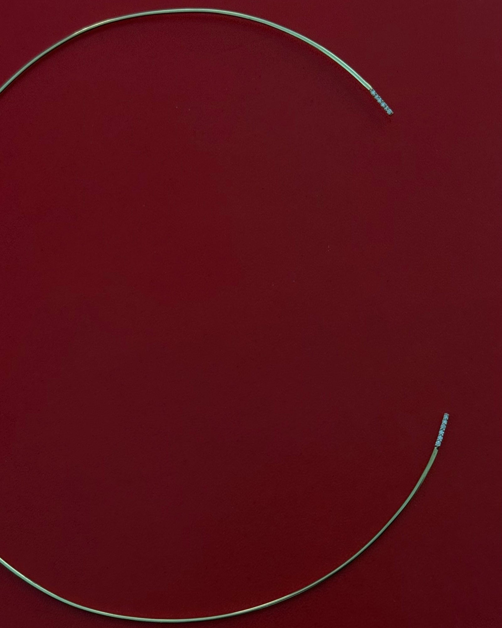 Studio still life of Lera Treyger Earth 14k gold diamond choker necklace on deep red leather background