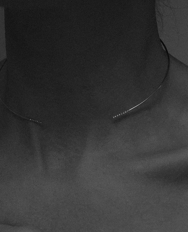 B&W detail of model's clavicle with Lera Treyger Earth 14k gold choker pavé tips against luminous skin