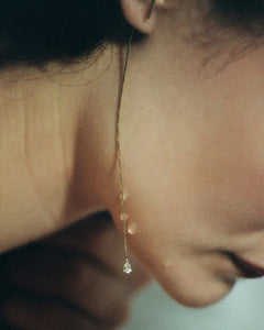 Detail of bare-shouldered model with wet skin wearing Lera Treyger MA 3 gold diamond threader along the neck