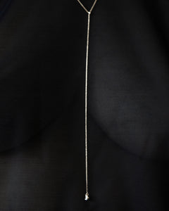 Color editorial of model in black silk wearing Lera Treyger MA 9 silver lariat with pear-diamond drop in V-neck