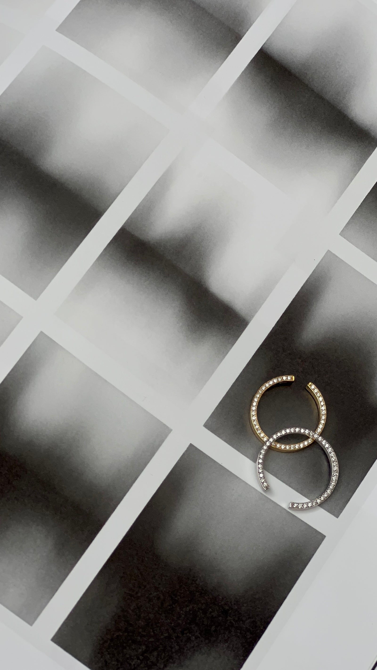 Two N 14 rings in yellow and white gold paired on tan textured photo paper