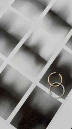 Two N 14 rings in yellow and white gold paired on tan textured photo paper