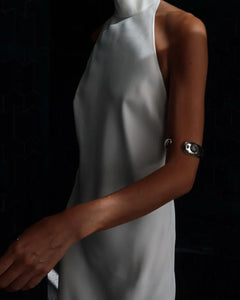 LT x O.RIM sterling silver cuff bracelet styled on the upper arm, model in gray pleated dress, editorial
