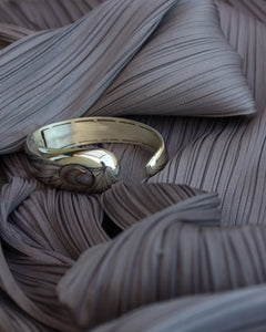 LT x O.RIM cuff bracelet in yellow gold, organic sculptural form with natural agate stone, pleated fabric backdrop