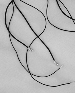 Sterling silver tip endings of the LT x O.RIM thin leather cord necklace, top-down detail shot