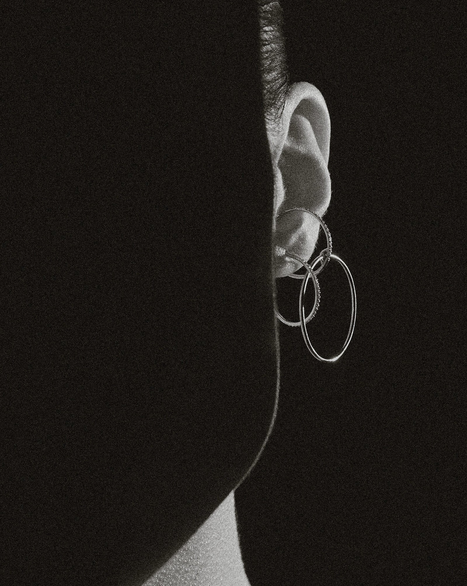 B&W ear macro of Lera Treyger Wind interlocked diamond and plain hoop ear cuff, dramatic side light